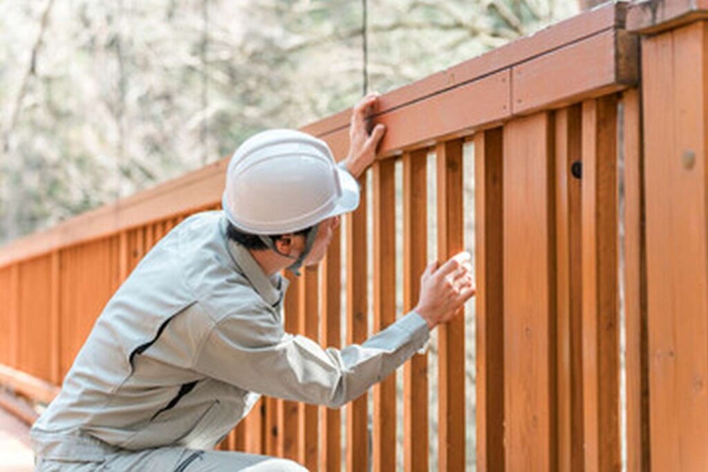 man wearing helmet is climbing fence with sign that says number 1 it